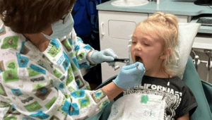 applying FluoroDose fluoride varnish to child at dentist office